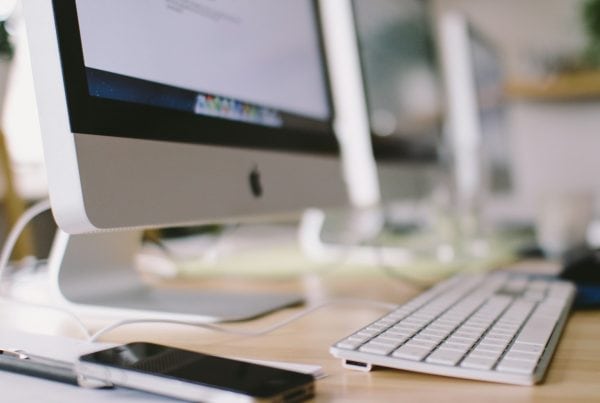 silver imac on brown wooden table